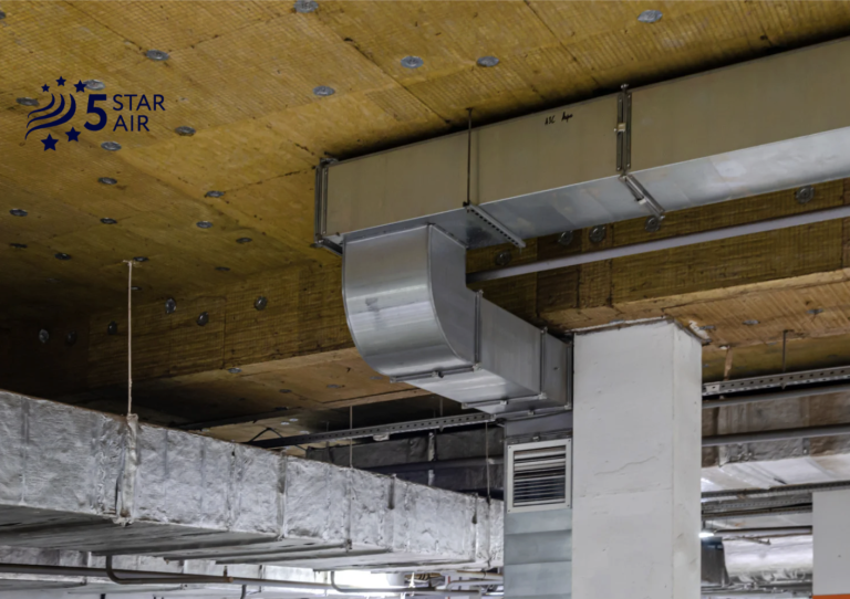 Professional industrial HVAC ductwork installation with galvanized steel metal ducts and yellow fiberglass insulation panels.